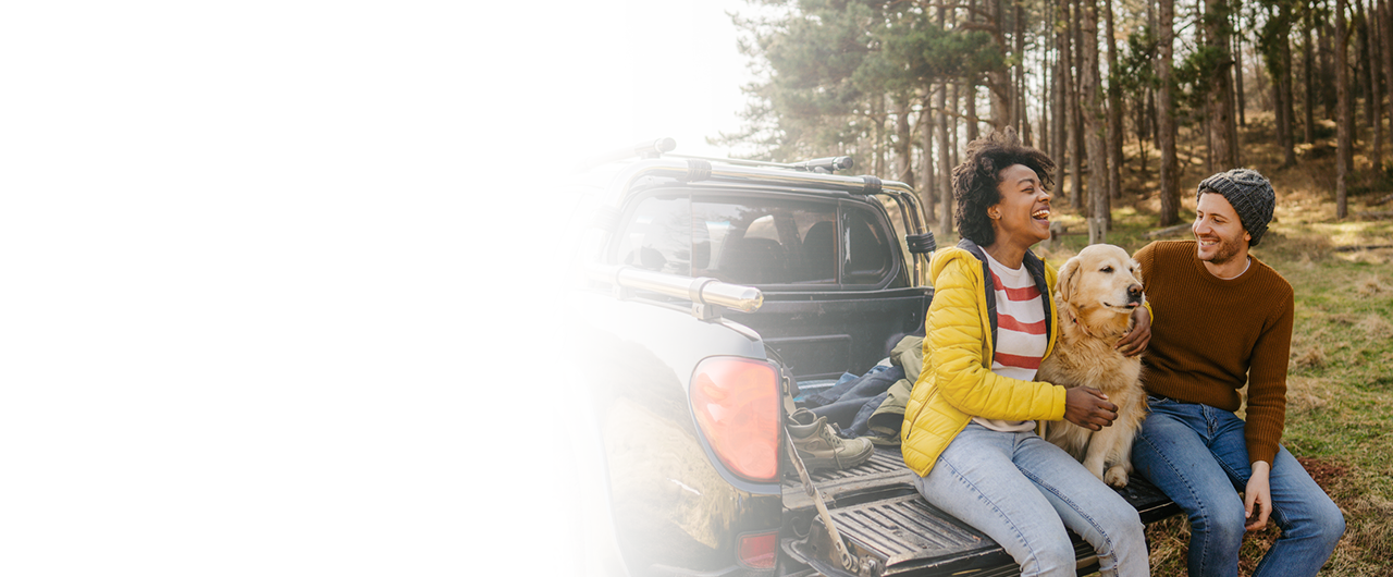 Couple sitting by a vehicle outdoors